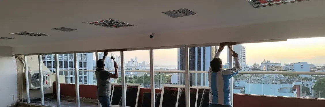 Dos operarios instalando un ventanal de piso a techo