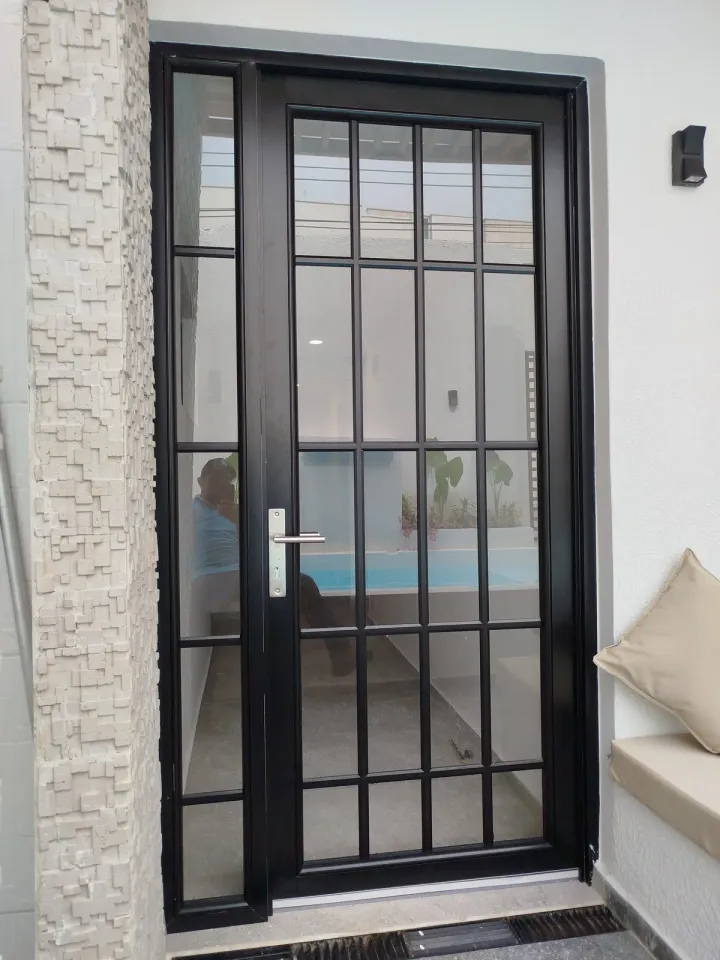 Puerta de aluminio negro con vidrio cuadriculado, cerrada, vista de frente