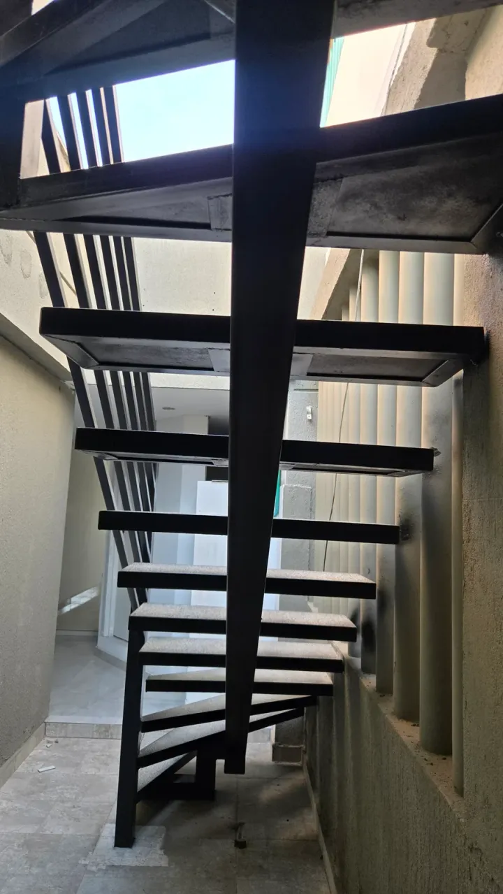 Escalera metálica negra interior, vista desde abajo