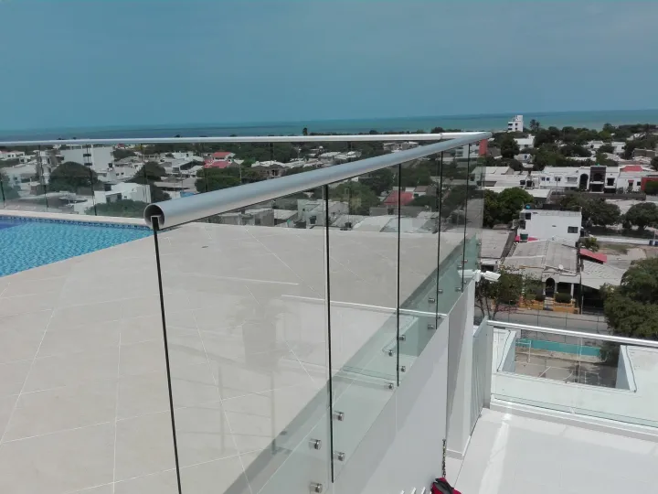 Baranda de vidrio con la piscina y el mar al fondo