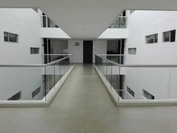 Corredor interior con barandas de vidrio a ambos lados