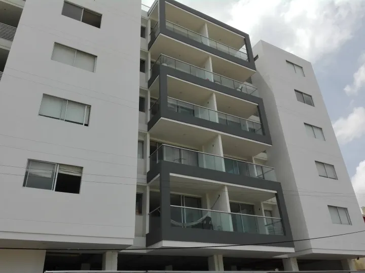 Fachada del edificio con los balcones de vidrio, en contrapicado